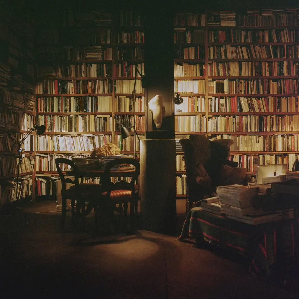 A dimly lit library with floor-to-ceiling bookshelves