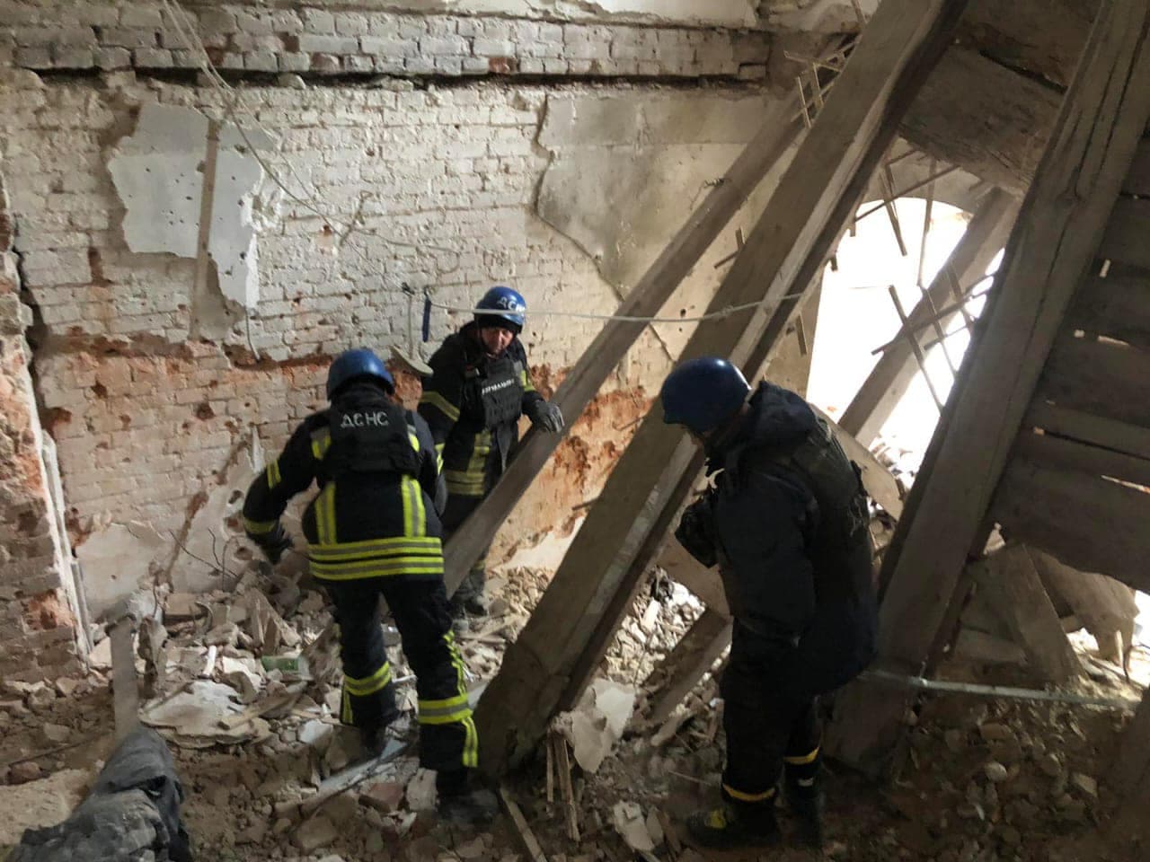Rescue workers clearing rubble from a shell-damaged building of the Sviatohirsk Lavra